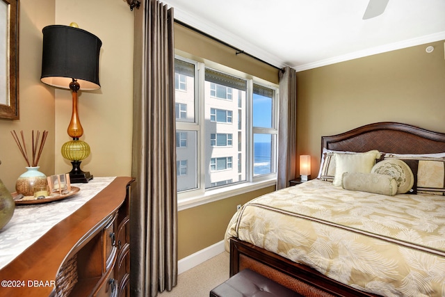 bedroom featuring ornamental molding, light colored carpet, a water view, and ceiling fan