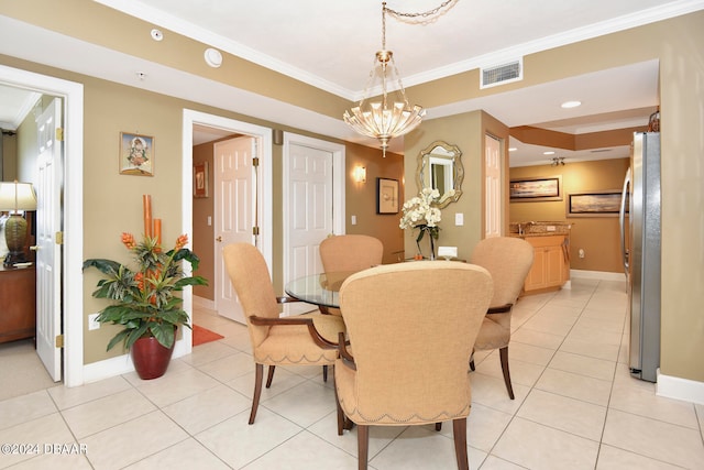 tiled dining area featuring an inviting chandelier and ornamental molding