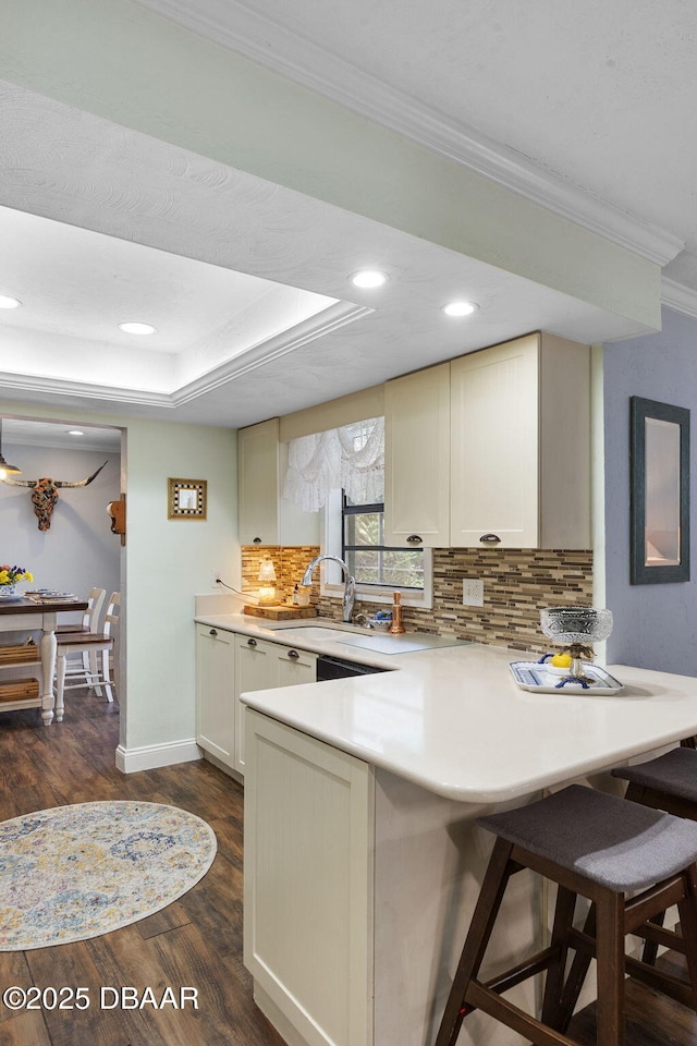552 Hamlet Dr, Port Orange, FL 32127 - kitchen with a peninsula, crown molding, tasteful backsplash, a kitchen bar, and light countertops