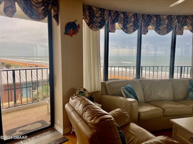 living room featuring a water view, a healthy amount of sunlight, and wood-type flooring