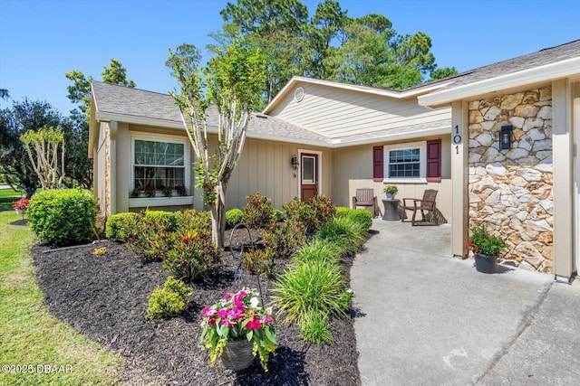 entrance to property featuring roof with shingles