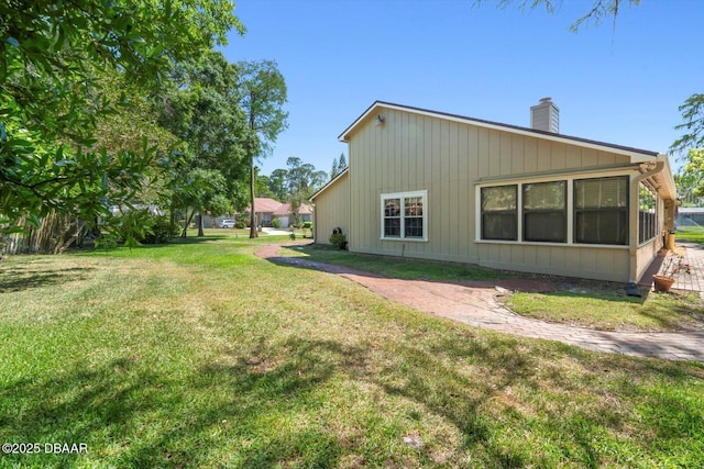 exterior space featuring a chimney and a yard