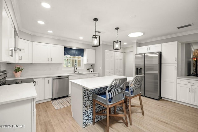 kitchen featuring ornamental molding, visible vents, a sink, and appliances with stainless steel finishes