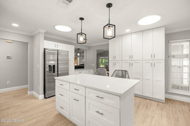 kitchen with white cabinets, baseboards, crown molding, stainless steel refrigerator with ice dispenser, and light countertops