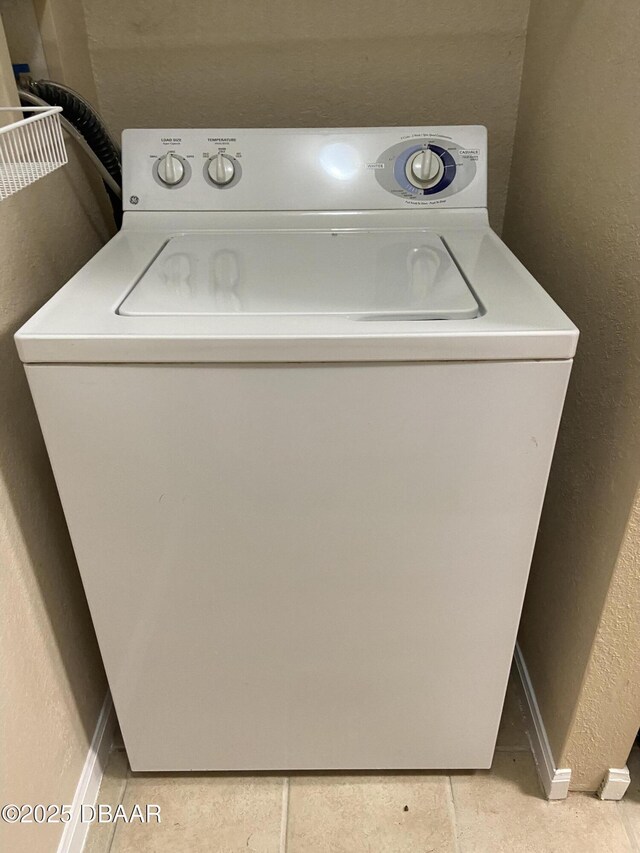 940 Village Trl Unit 6-109, Port Orange, FL 32127 - laundry room featuring washer / clothes dryer, a textured wall, light tile patterned flooring, and baseboards