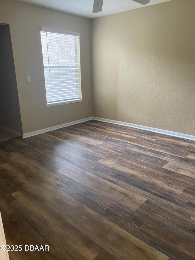 940 Village Trl Unit 6-109, Port Orange, FL 32127 - empty room with dark wood-style floors, ceiling fan, and baseboards