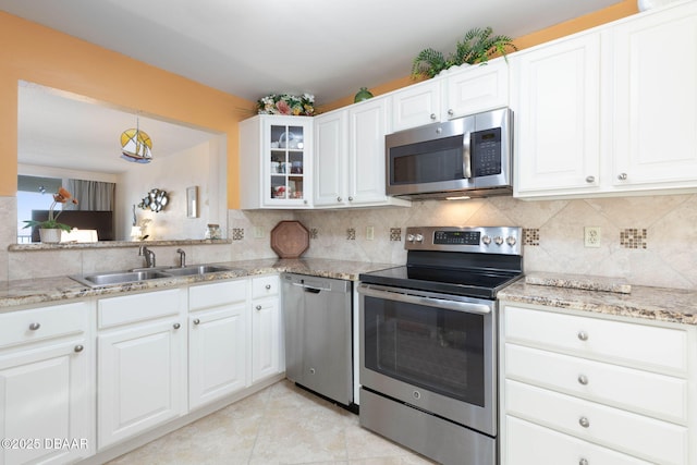 89 S Atlantic Ave Unit 1004, Ormond Beach, FL 32176 - kitchen featuring appliances with stainless steel finishes, tasteful backsplash, glass insert cabinets, and white cabinets