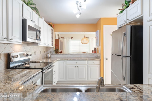 89 S Atlantic Ave Unit 1004, Ormond Beach, FL 32176 - kitchen featuring appliances with stainless steel finishes, white cabinetry, decorative backsplash, and light stone counters
