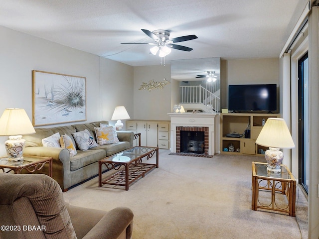 carpeted living room with a textured ceiling, a fireplace, and ceiling fan