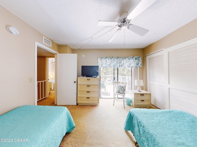 carpeted bedroom with ceiling fan, a textured ceiling, a closet, and access to outside