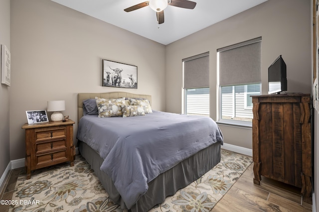 bedroom with baseboards, ceiling fan, and light wood-type flooring