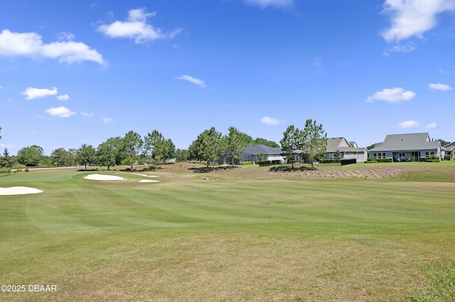 view of home's community featuring a lawn, golf course view, and a residential view