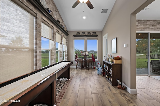 sunroom featuring baseboards, wood finished floors, and visible vents