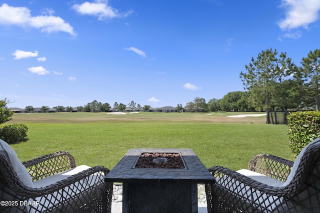 view of yard with golf course view and an outdoor fire pit