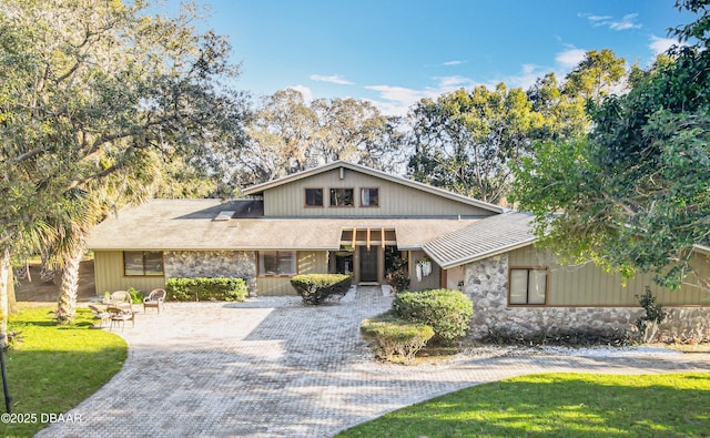 view of front of property featuring driveway and stone siding