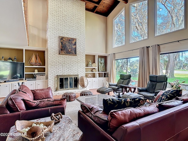 living room featuring built in shelves, wooden ceiling, a brick fireplace, beam ceiling, and carpet