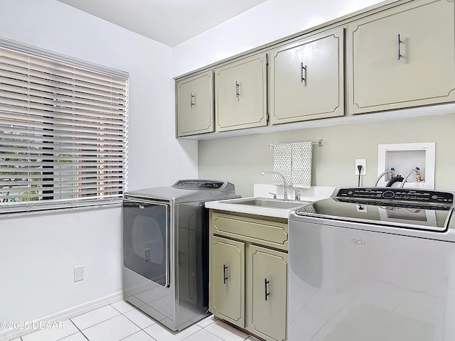 laundry area with cabinet space, light tile patterned floors, a sink, and washing machine and clothes dryer