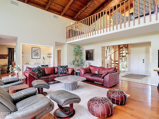 living area featuring wood ceiling, stairway, wood finished floors, and visible vents