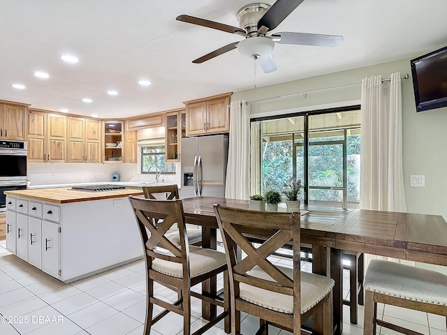 kitchen featuring recessed lighting, butcher block countertops, stainless steel appliances, glass insert cabinets, and a ceiling fan
