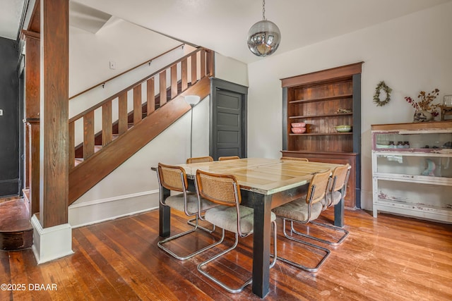 dining space featuring wood-type flooring and built in shelves