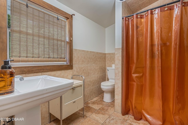 bathroom featuring tile walls and toilet