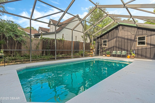 view of pool with glass enclosure and a patio