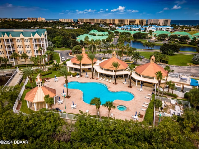 view of swimming pool with a water view and a patio area