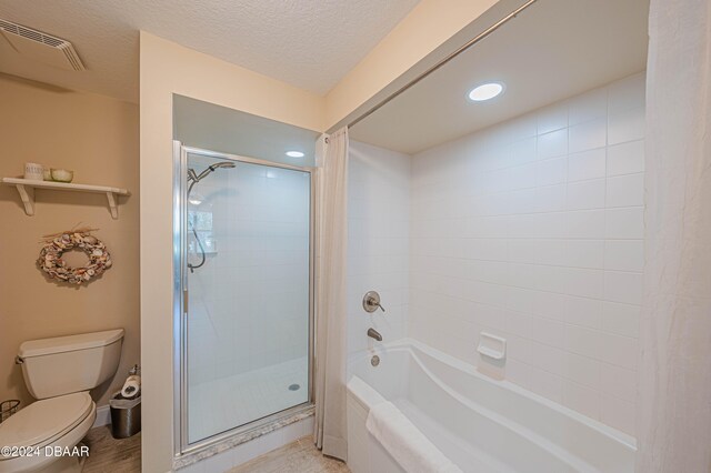 bathroom with a textured ceiling, hardwood / wood-style flooring, toilet, and plus walk in shower