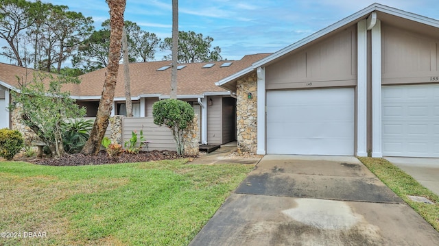 single story home featuring a garage and a front lawn