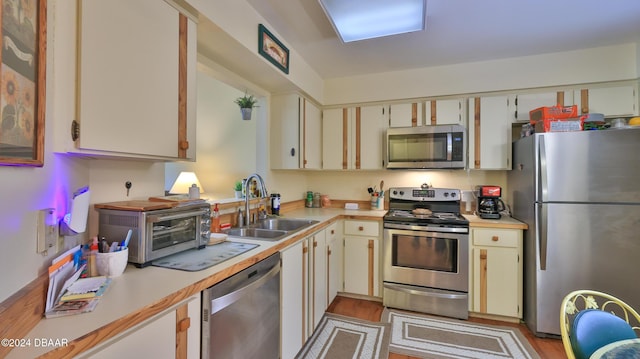 kitchen with sink, stainless steel appliances, and cream cabinets