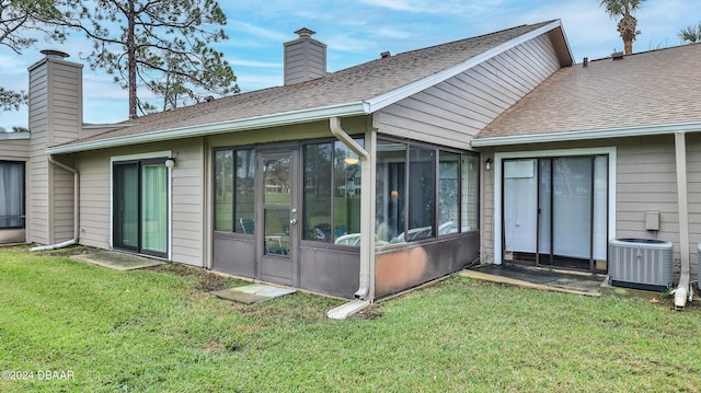 back of house featuring a lawn and central AC unit