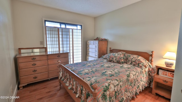 bedroom featuring wood-type flooring and a textured ceiling