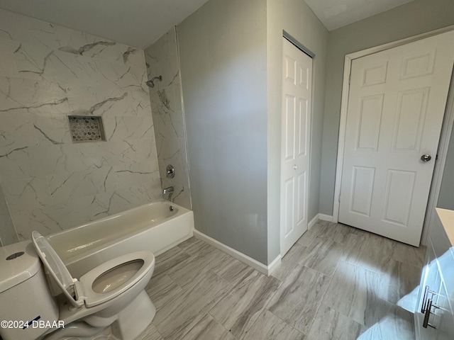 bathroom with tiled shower / bath combo and toilet