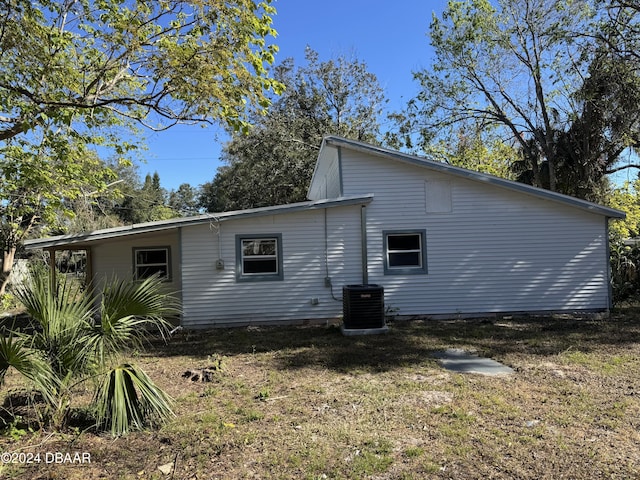 view of side of property with a lawn and central AC