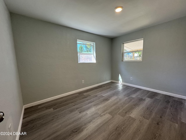 spare room with a healthy amount of sunlight and dark hardwood / wood-style floors