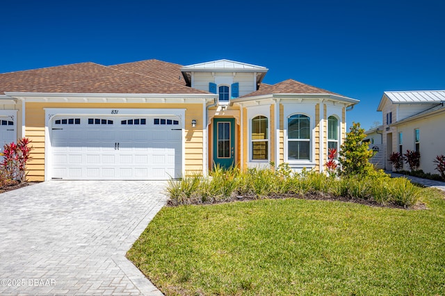 831 Coral Reef Way, Daytona Beach, FL 32124 - view of front of property with a front yard, decorative driveway, and a garage