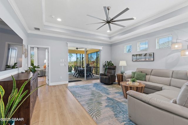 831 Coral Reef Way, Daytona Beach, FL 32124 - living room featuring visible vents, ornamental molding, light wood-style floors, a raised ceiling, and ceiling fan