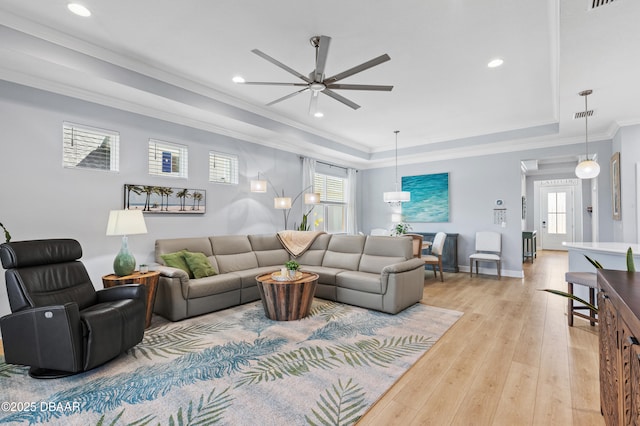 831 Coral Reef Way, Daytona Beach, FL 32124 - living area featuring light wood-type flooring, a raised ceiling, a healthy amount of sunlight, and a ceiling fan