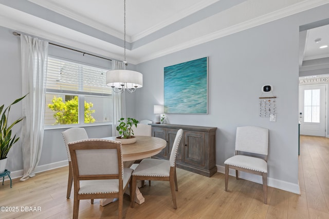 831 Coral Reef Way, Daytona Beach, FL 32124 - dining room with a notable chandelier, a raised ceiling, light wood-style flooring, crown molding, and baseboards