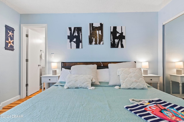 bedroom with hardwood / wood-style flooring and a textured ceiling