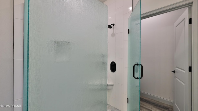 bathroom featuring wood-type flooring and a shower with shower door