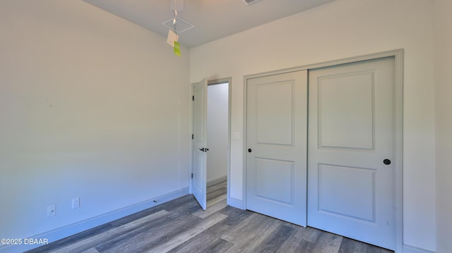 unfurnished bedroom featuring hardwood / wood-style flooring and a closet