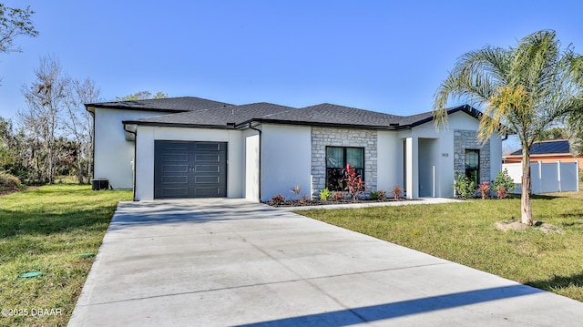 view of front facade featuring central air condition unit, a front yard, and a garage