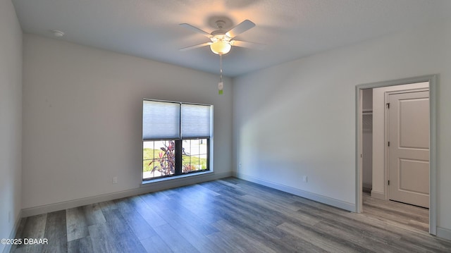 empty room with ceiling fan and light hardwood / wood-style flooring