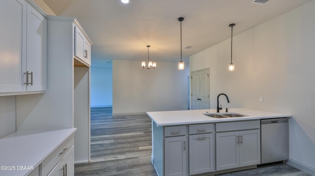 kitchen featuring stainless steel dishwasher, decorative light fixtures, sink, and kitchen peninsula