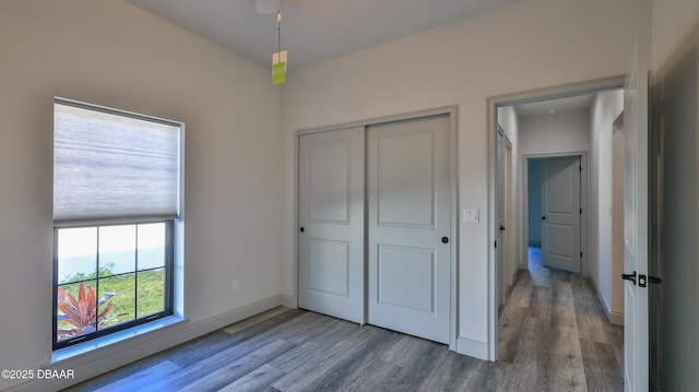 unfurnished bedroom featuring a closet and hardwood / wood-style flooring