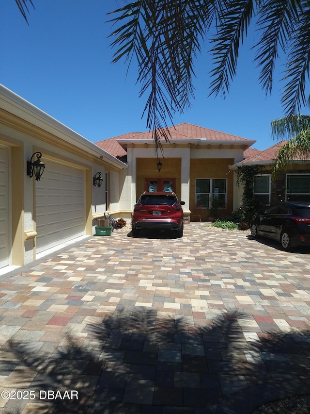 view of front of property with a garage, metal roof, and stucco siding