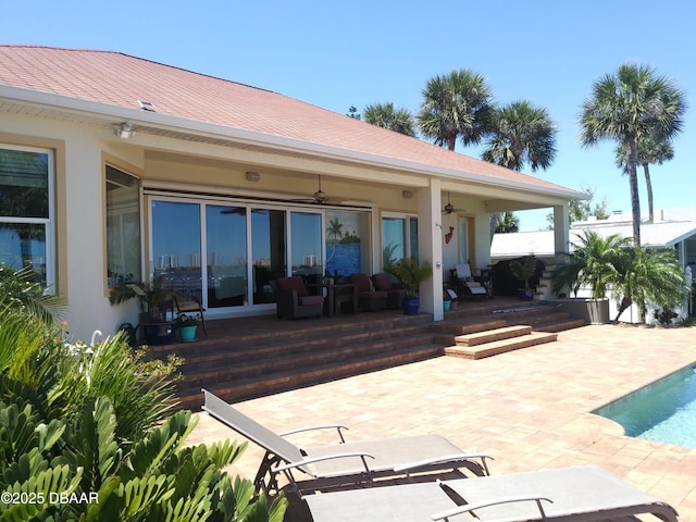 back of property featuring a ceiling fan, a patio, a shingled roof, and stucco siding