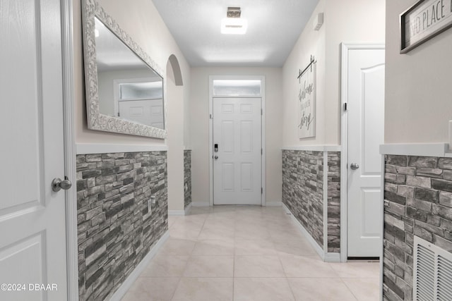 interior space featuring a textured ceiling and light tile patterned flooring