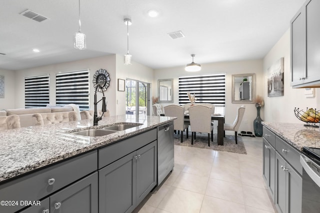 kitchen with light stone countertops, appliances with stainless steel finishes, sink, decorative light fixtures, and gray cabinets